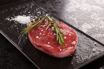 Raw meat, beef steak on black background.