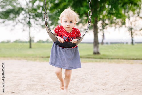 Portrait Of Happy Smiling Little Toddler Girl Swinging On