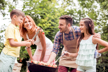 Wall Mural - Young family having barbecue party in their garden