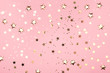 Golden stars glitter on pink background.