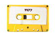 A vintage cassette tape from the 1980s era (obsolete music technology) with the text 1977 printed over it (my addition, not in the original image). Color: white label, yellow plastic.
