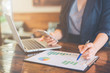 © apichon_tee - Business woman working on analysis charts and graphs showing results.