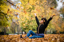 Smiling Teen Girl Throwing Leaves In The Air