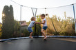 Little kids bouncing off the trampoline taut