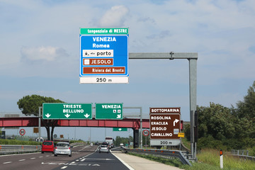 Big road sign on the highway with directions to go to many Itali