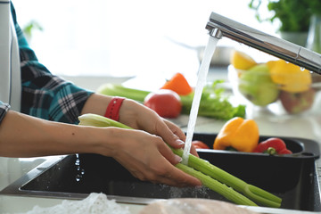 Hands woman washing vegetables. Preparation of fresh salad.