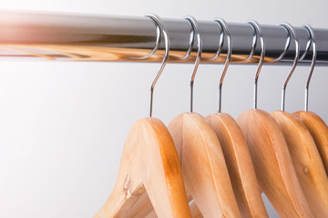 Wooden hangers on rail close-up.