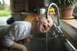 © Wavebreak Media - Boy drinking water from faucet in kitchen