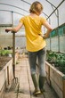 © Wavebreak Media - Woman with digging fork standing in greenhouse