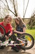 © Wavebreak Media - Mother and daughter repairing bicycle at backyard