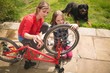 © Wavebreak Media - Mother and daughter repairing bicycle at backyard
