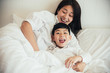 © ic36006 - Happy loving family. Mother and her son playing on the bed in bedroom.