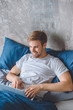 © LIGHTFIELD STUDIOS - happy handsome man using laptop in bed at home