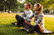 Fitness loving couple friends in park make meditate exercises.