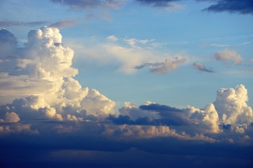Wall Mural - dramatic colorful cloud formations with blue sky and sun