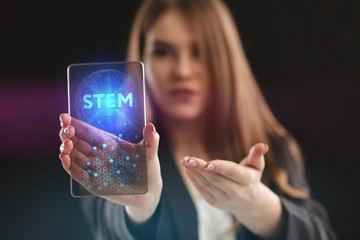 The concept of business, technology, the Internet and the network. A young entrepreneur working on a virtual screen of the future and sees the inscription: STEM