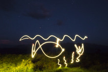 Freezelight Drawing By Light Of A LED Flashlight In The Air With Mountains And Sky In The Background