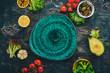 © Yaruniv-Studio - Green plate on a wooden background with vegetables. On a wooden table. Top view. Copy space.
