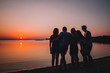 © Anna - Holiday with friends in nature. Silhouette of friends at the beach looking on the sunset in the summer evening