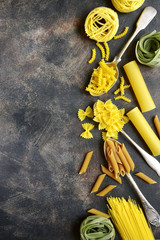 Various types of dry pasta : spaghetti, penne, farfalle, tagliatelle, fettuccine and cannelloni.Top view with copy space.