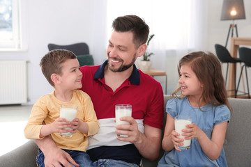 Canvas Print - Happy family with glasses of milk in living room