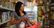 © Mark Adams - Young black mother at the grocery store shopping for her family