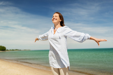 people and leisure concept - happy smiling woman on summer beach