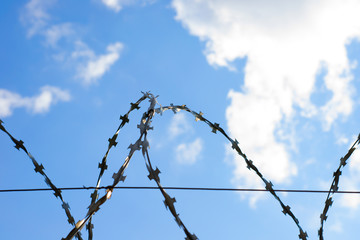 Part of barbed wire on the background of amazing blue sky