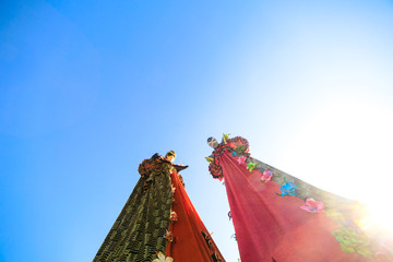 Wall Mural - Young people on stilts posing against the blue sky.