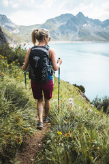 Wall Mural - adventurous sportive girl hiking in beautiful alpine mountains next to a lake
