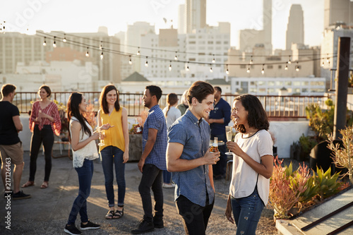 Fotomural Friends Gathered On Rooftop Terrace For Party With City Skyline In Background