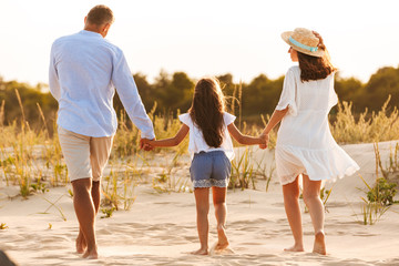 Wall Mural - Happy family having fun together at the beach.