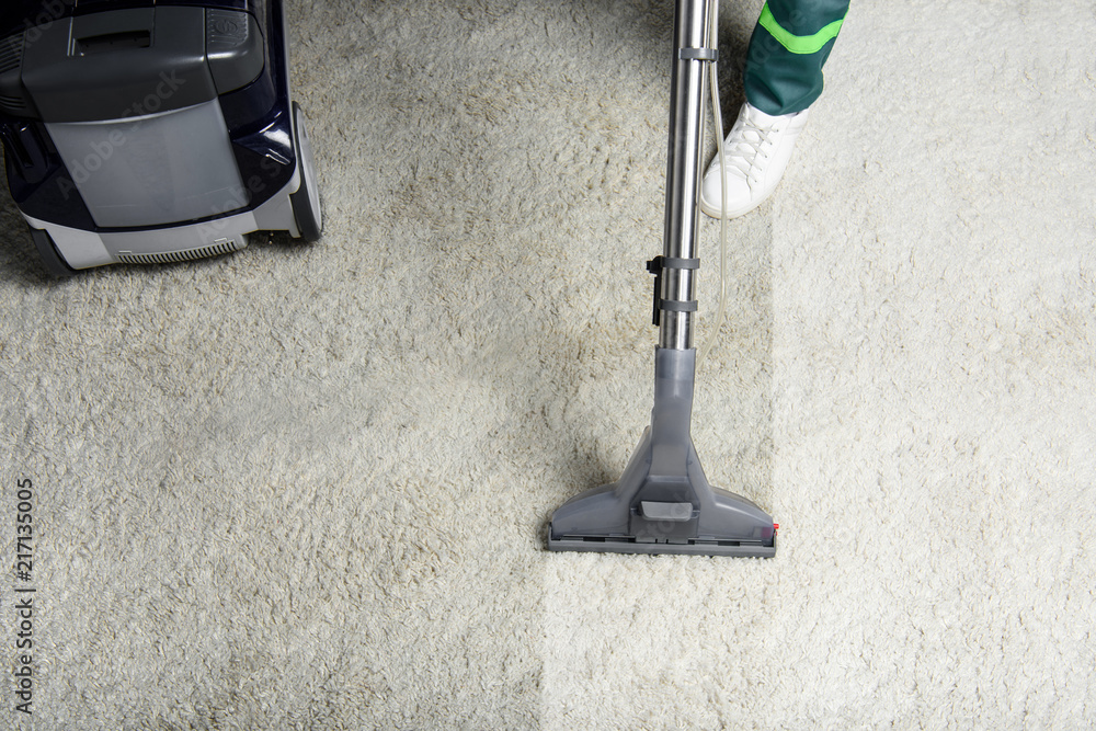 high angle view of person cleaning white carpet with professional vacuum cleaner - obrazy, fototapety, plakaty 