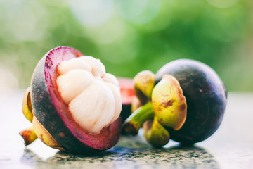 Mangosteen fruit against blurred green background for food and eating concept