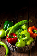 various harvested peppers and hot peppers in basket