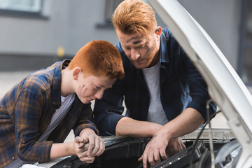 Wall Mural - father and son repairing car and looking in open hood