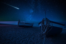Perseid Meteor Shower And The Milky Way Over Boats On The Beach