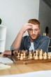 © LIGHTFIELD STUDIOS - handsome pensive man looking at chessboard at home