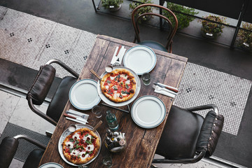 Wall Mural - top view of different freshly baked pizza on trays at restaurant