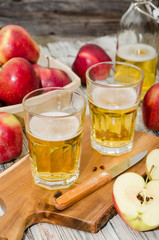 Apple cider and a basket with fresh apples on rustic wooden  background 