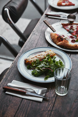 Wall Mural - close-up shot of delicious pizza and lasagne on wooden table