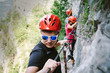 © Stillkost - Friends who are climbing along a via ferrata