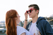 © Viacheslav Yakobchuk - You are stylish. Positive young woman putting sunglasses on her boyfriend while having fun with him