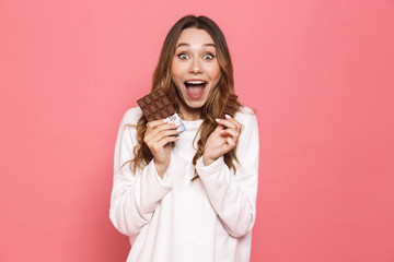 Portrait of a happy young woman holding chocolate bar