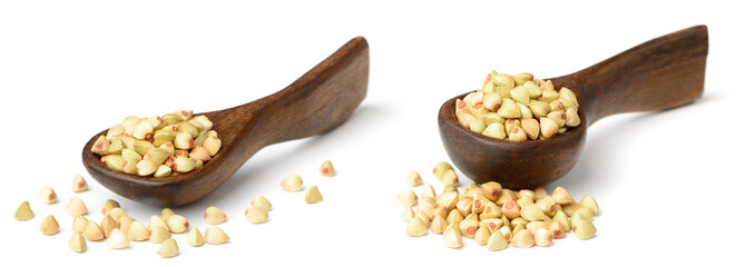 uncooked buckwheat in the wooden spoon, isolated on the white background.