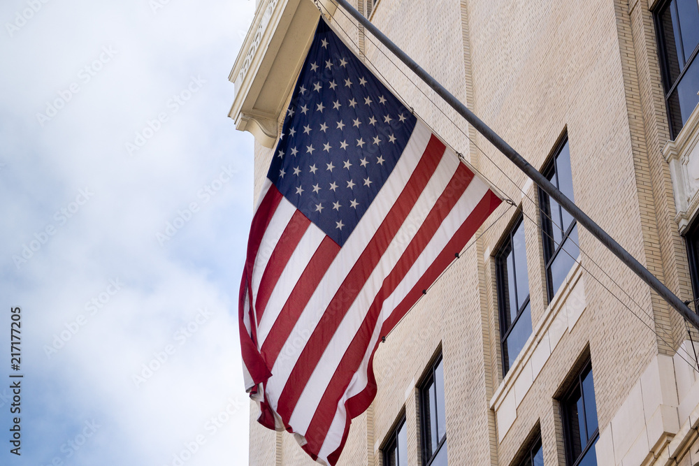 Obraz na płótnie US flag displayed from traditional Los Angeles downtown city building. w salonie