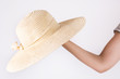 © Emilija - Young girl holding big yellow straw hat on hand isolated on white background. Summer clothes concept. Close up, selective focus