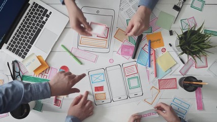 Small team of young UX designers creating mobile app layout