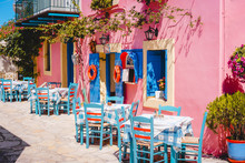 Traditional Greek Vivid Lilac Colored Tavern On The Narrow Mediterranean Street On Hot Summer Day