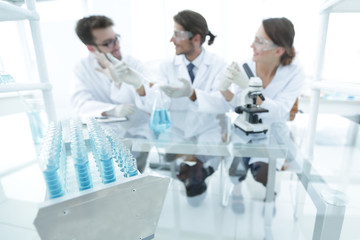 Wall Mural - background image of scientists studying blue liquid in a flask